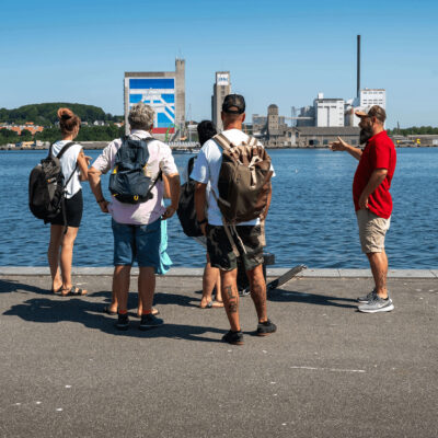 Billede af Kenneth som snakker med en turistgruppe på havnen